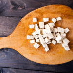 Cubed tofu on wooden cutting board