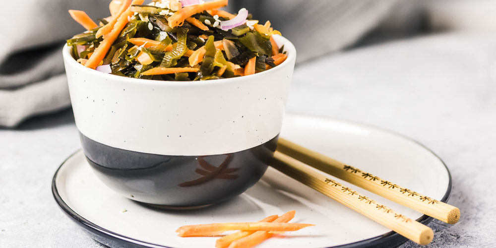 Seaweed. Carrot and onions in a bowl with chopsticks.