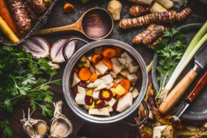 Vegetables surrounding pot of vegetable stew