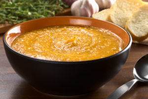 Sweet potato soup in black bowl (orange inner)