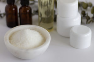 Marble bowl of Epsom salts with spa bottles and jars.