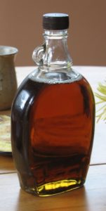 Bottle of maple syrup on table.